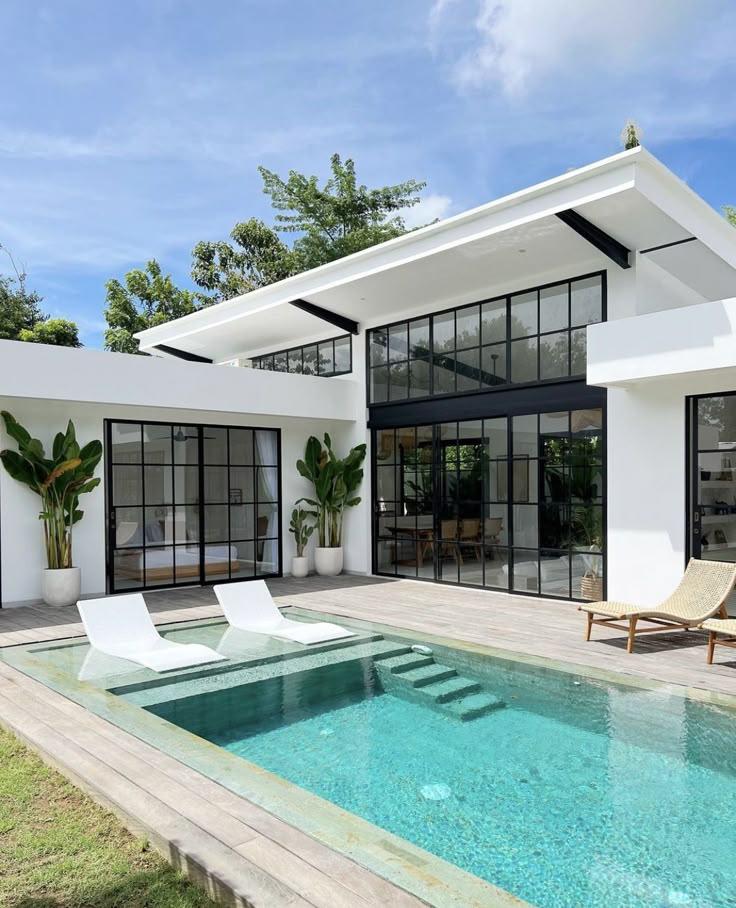 Modern Villa Exterior with Poolside Lounge Chairs Alzad Real Estate